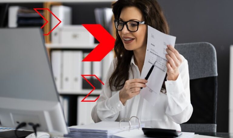 Profissional de contabilidade analisa documentos e dados em frente ao computador, representando o envio de informações e obrigações acessórias através do SPED Fiscal para garantir conformidade tributária e eficiência na gestão empresarial.