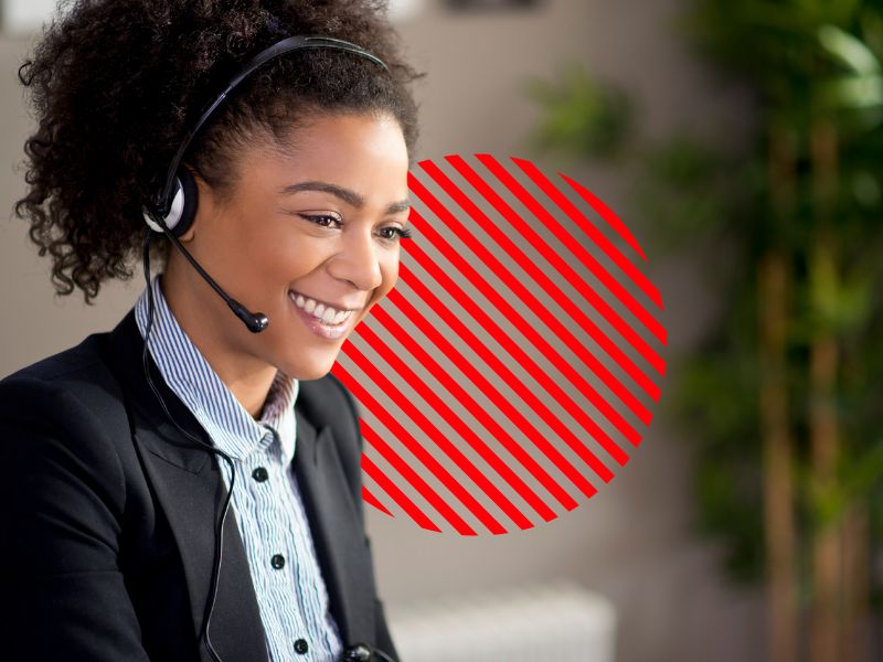 Profissional de atendimento sorri enquanto auxilia cliente com fone de ouvido, representando o uso de uma ordem de serviço digital para gerenciar atendimentos e melhorar a eficiência operacional das empresas de serviços.