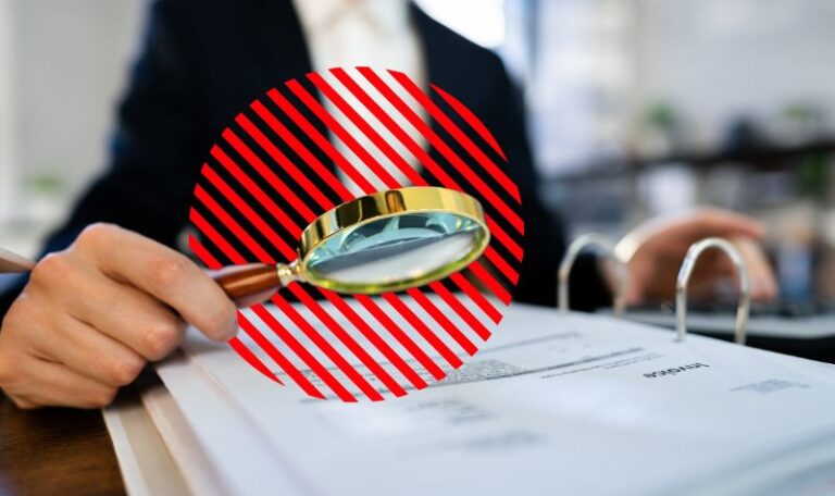 Profissional analisa documentos fiscais com lupa sobre mesa de trabalho, representando a substituição tributária como mecanismo de fiscalização e controle na apuração e recolhimento antecipado de impostos.