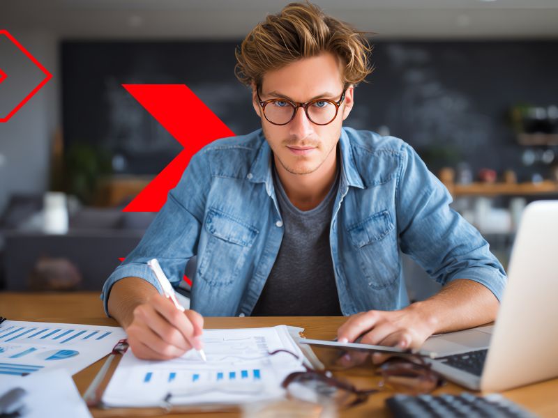 Profissional analisa relatórios financeiros e faz anotações ao lado de notebook, representando o planejamento e acompanhamento do fluxo de caixa projetado para garantir previsibilidade e controle financeiro da empresa.