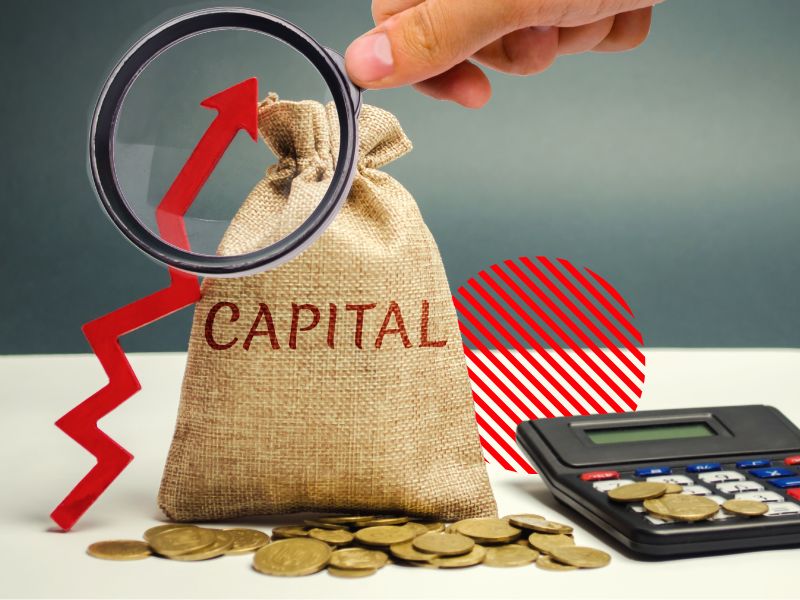 Representação de capital de giro com moedas, calculadora e símbolo de crescimento, indicando a importância do controle financeiro e da gestão eficiente dos recursos para manter a operação da empresa.