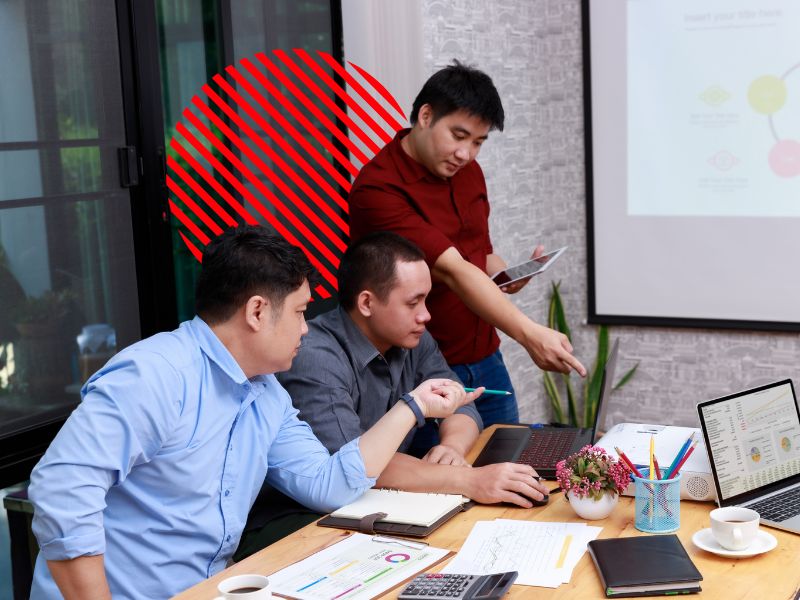 Equipe analisa relatórios e indicadores em reunião de trabalho, representando o compliance empresarial para garantir conformidade, controle de processos e segurança na gestão corporativa.