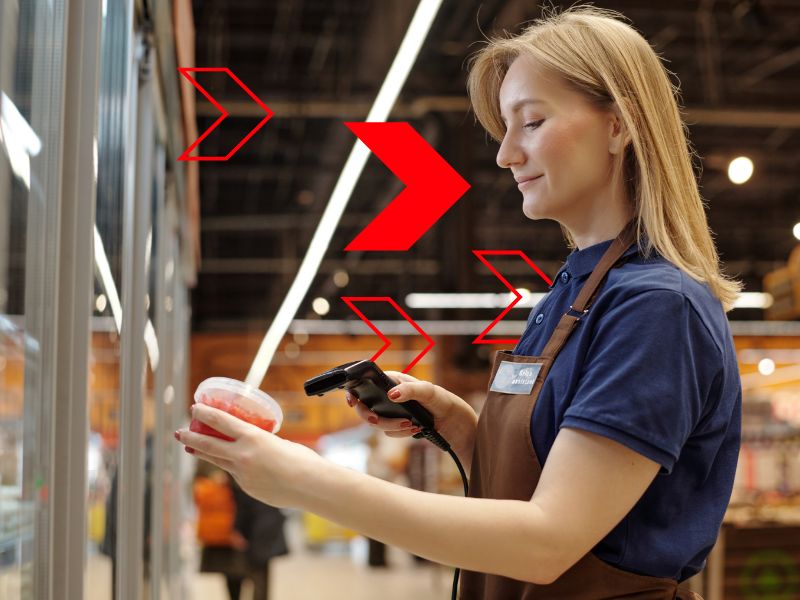 Profissional realiza leitura de produto com coletor de código de barras em ambiente comercial, representando o controle de compras integrado ao estoque para garantir reposição eficiente, reduzir desperdícios e melhorar a gestão operacional.