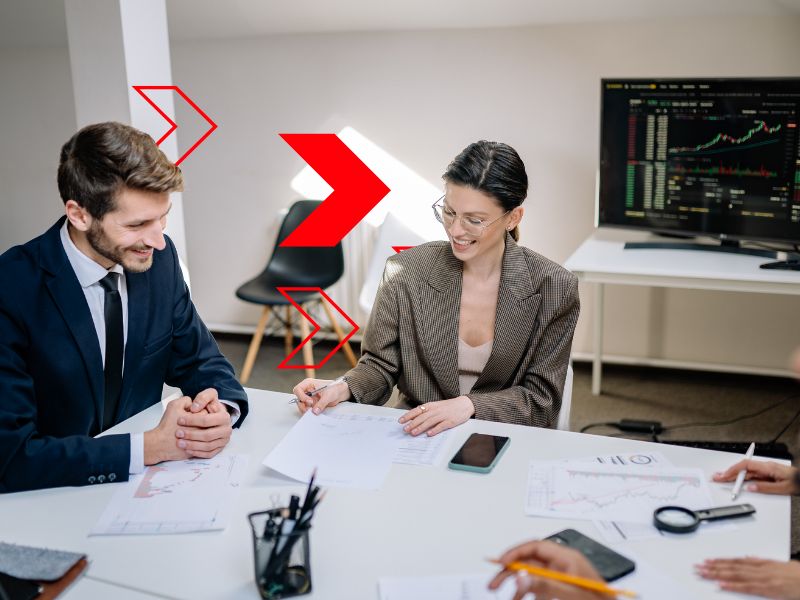 Equipe analisa relatórios financeiros e indicadores de desempenho em reunião corporativa, representando o uso da DRE gerencial para acompanhar receitas, custos, despesas e lucratividade, apoiando decisões estratégicas e o controle financeiro empresarial.