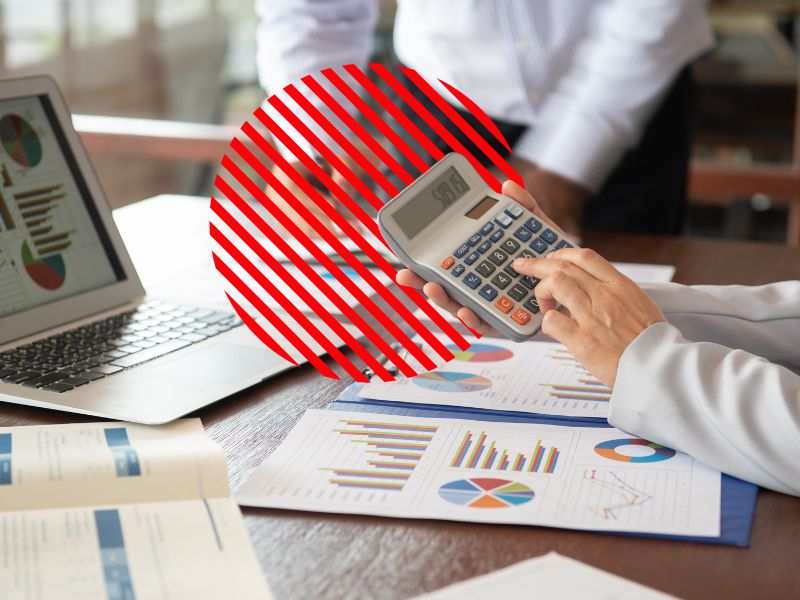 Profissional analisa relatórios e realiza cálculos financeiros com apoio de gráficos e indicadores, representando o acompanhamento de indicadores financeiros para avaliar resultados, monitorar a saúde financeira da empresa e apoiar decisões estratégicas baseadas em dados.