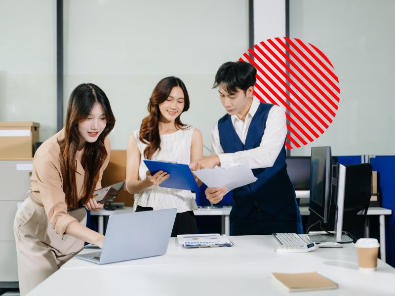 Equipe colaborando com documentos e sistema de gestão, representando a automação de processos empresariais para integrar setores, reduzir tarefas manuais e aumentar a eficiência operacional.