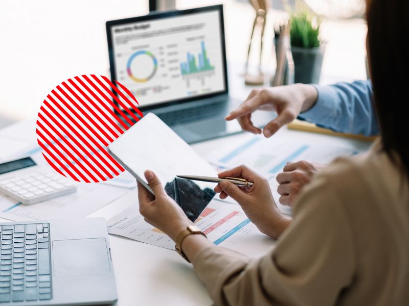 Profissionais analisando indicadores financeiros em tablet e notebook para identificar despesas invisíveis, reduzir desperdícios e fortalecer o controle financeiro empresarial.