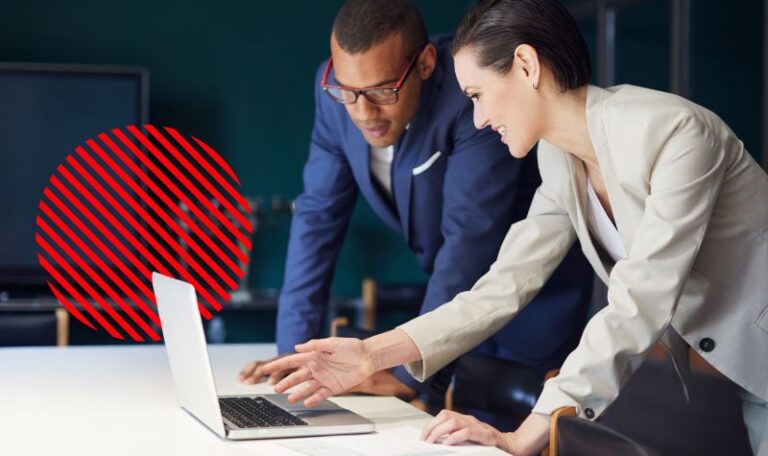 Profissionais analisando informações em um notebook, representando um ERP integrado que conecta setores, centraliza dados e melhora a tomada de decisão empresarial.