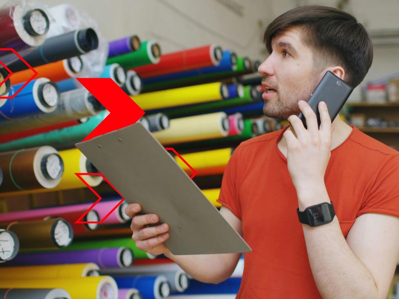 Profissional analisando informações de estoque e conversando por telefone durante a avaliação de fornecedores, garantindo qualidade, confiabilidade e eficiência no processo de compras.
