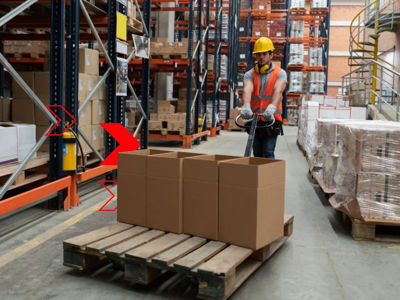 Colaborador movimentando cargas em centro de distribuição, representando a logística empresarial integrada para otimizar estoque, expedição, entregas e eficiência operacional.