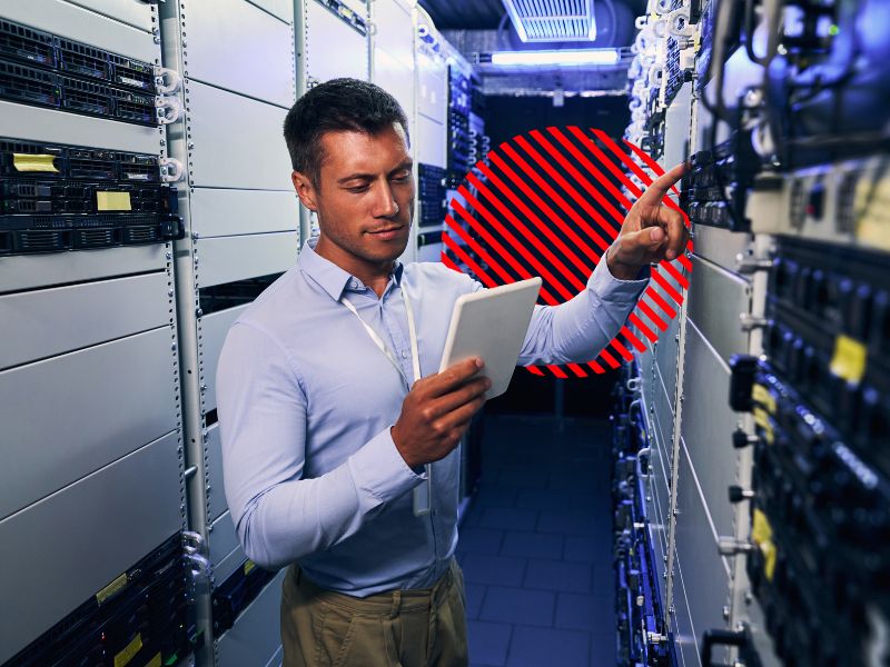 Profissional verificando equipamentos de tecnologia durante uma manutenção preventiva, ajudando a identificar falhas antes que afetem a operação