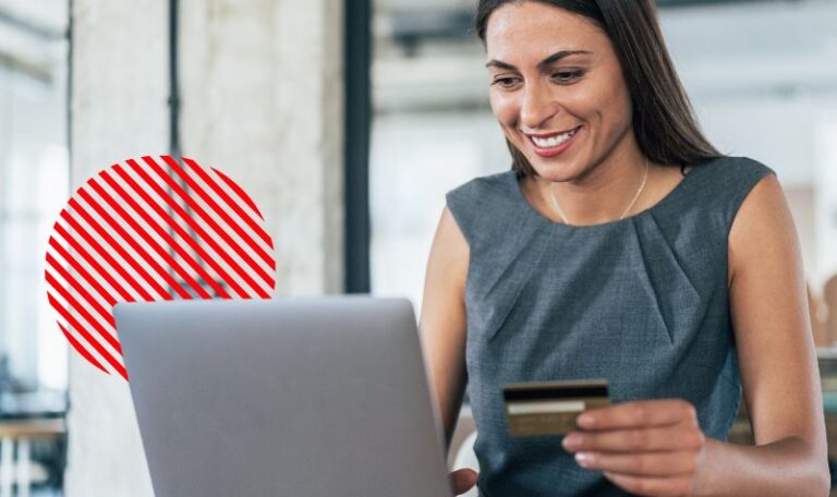 Mulher sorrindo segurando cartão de crédito ao lado do notebook, representando os prazos de pagamento e recebimento do ciclo de conversão de caixa