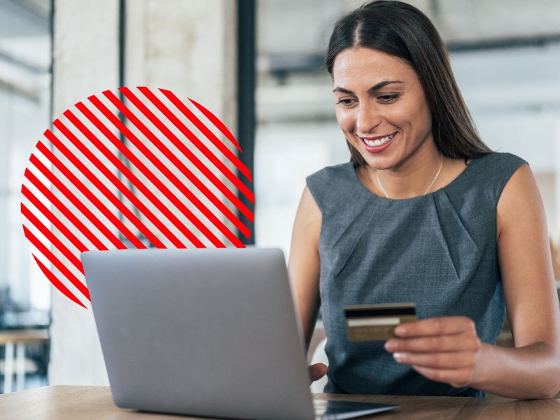 Mulher analisa pagamentos no laptop enquanto segura um cartão, em imagem de apoio ao artigo sobre prazo médio de pagamento.